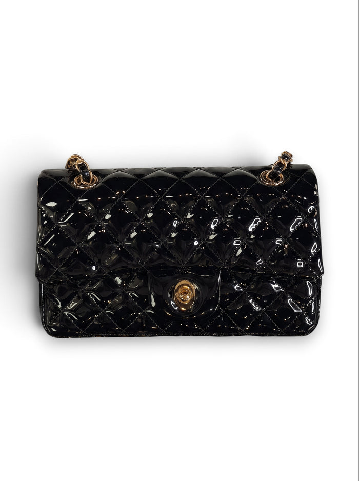 Zimoras Boutique black quilted patent vegan leather shoulder bag with gold-tone chain strap and turn-lock closure.