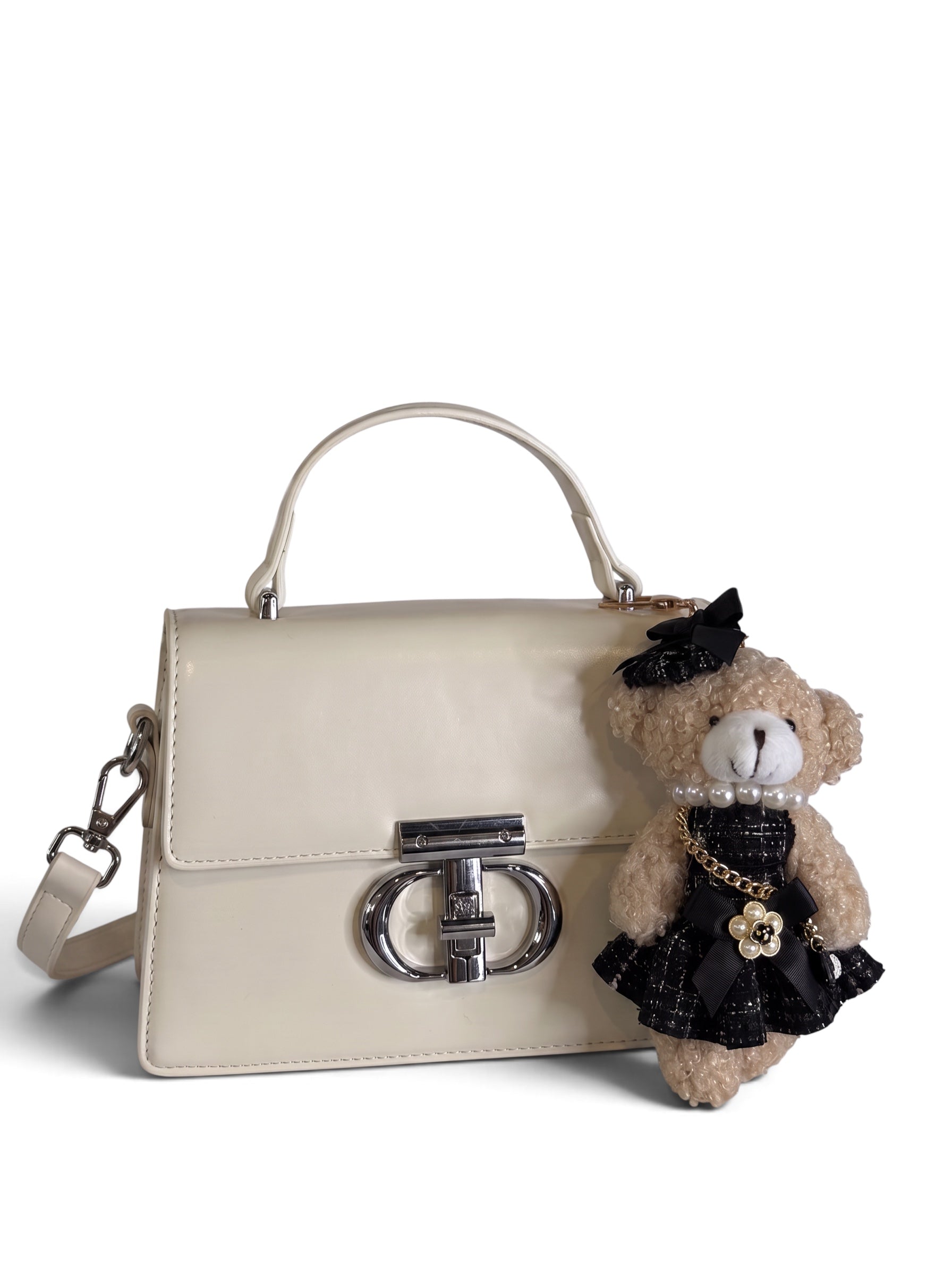 Zimoras Boutique ivory vegan leather top handle crossbody bag with silver hardware and a removable teddy bear charm.